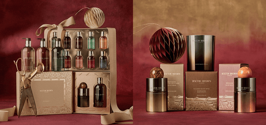 Elegant bottles of Molton Brown bath and shower gels in rich colours against a warm background, surrounded by bubbles and festive packaging. Represents luxury self-care and premium beauty offers available through Purpl Disabled Discounts, including exclusive savings on Molton Brown gift sets and fragrances.