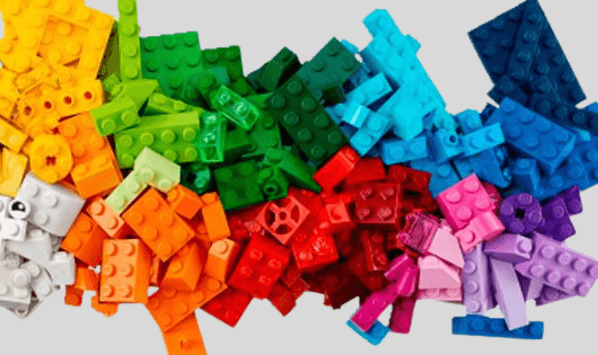 A colourful pile of LEGO bricks sorted by shade from white to violet, symbolising creative play and inclusive learning, ideal for sensory development and indoor activity ideas for disabled children and teens in the UK.