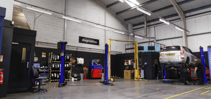 Halfords autocentre workshop with mechanics servicing car Purpl disabled discounts members save on vehicle diagnostics and car repairs