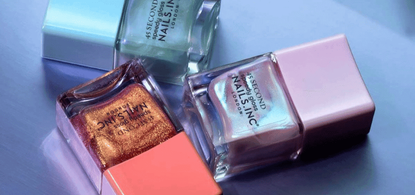 Nails Inc nail polish bottles in metallic shades on a glossy surface, beauty discounts for disabled people.