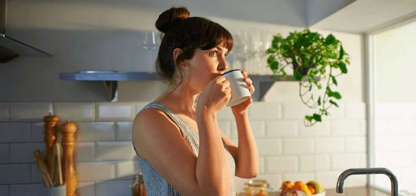 Woman drinking tea in kitchen, ScottishPower Purpl discounts for disabilities and long term health conditions, mobility discounts and offers.