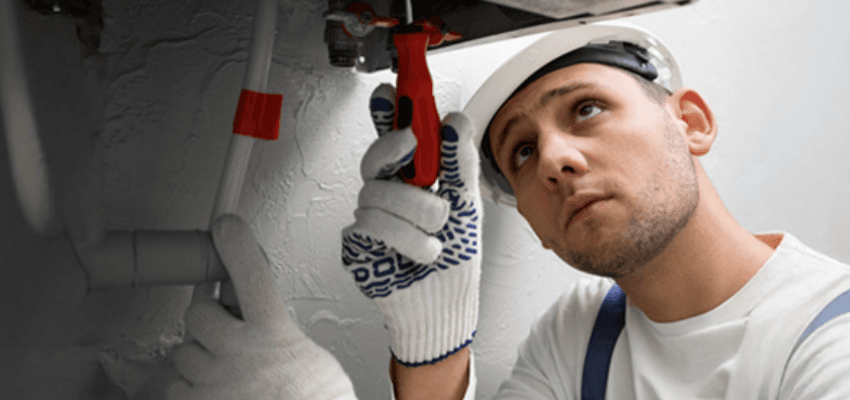Boiler repair engineer fixing a broken heating system using specialist tools indoors. Home boiler cover for disabled people UK with affordable central heating protection plans and emergency breakdown services.