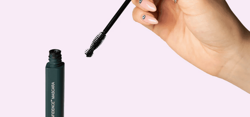 Hand holding mascara wand above tube, Human Beauty, Purpl discounts for disabilities and long term health conditions, shopping discounts for disabled people.