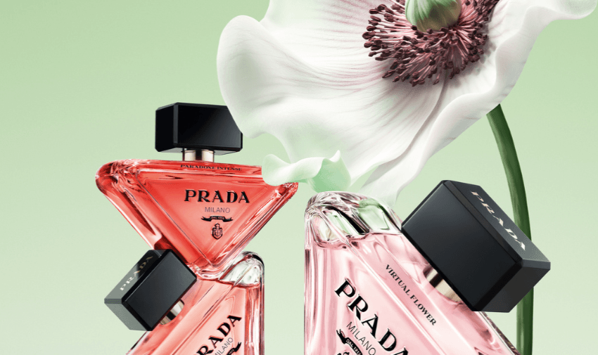 Two bottles of Prada Milano perfume in pink glass with black square lids, set against a soft green background with a large blooming white and purple flower, representing luxury fragrance products available with exclusive discounts