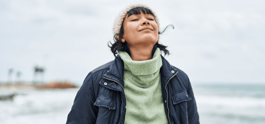 Woman enjoying seaside air, Holland & Barrett Purpl discounts for disabilities and long term health conditions, mobility discounts and offers.