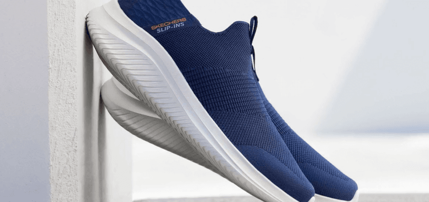 Navy slip-on trainers leaning on wall, Skechers Purpl discounts for disabilities and long term health conditions, mobility discounts and offers.