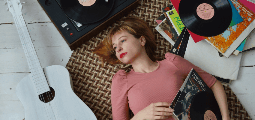 Woman relaxing with vinyl records and guitar, RareVinyl Purpl discounts for disabilities and long term health conditions, shopping discounts for disabled people.