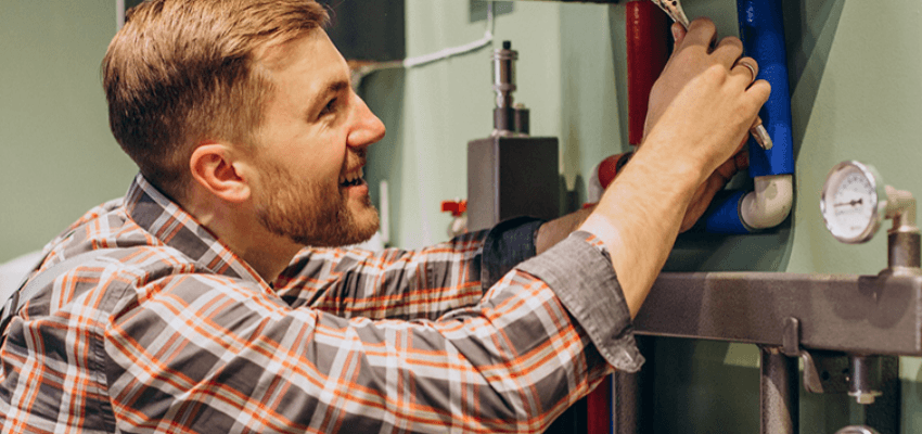 Friendly gas engineer servicing a domestic boiler system in a home. Inclusive boiler insurance for disabled people UK with nationwide emergency heating repairs and disabled household protection plans.