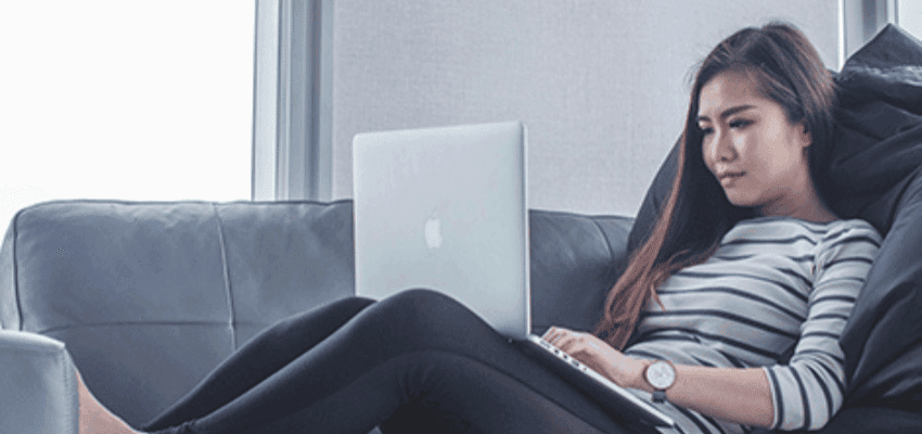 Woman using laptop on sofa, Stone Refurb Purpl discounts for disabilities and long term health conditions, shopping discounts for disabled people.