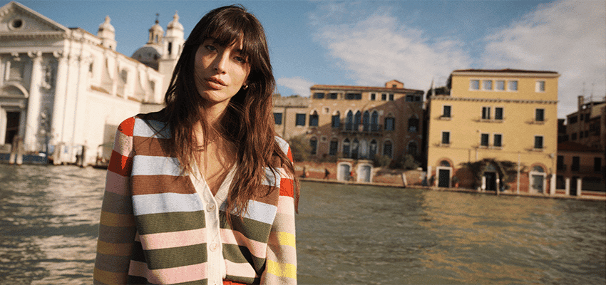 Woman by Venetian canal in Boden knitwear, Purpl discounts for disabilities and long term health conditions, disabled travel discounts UK.