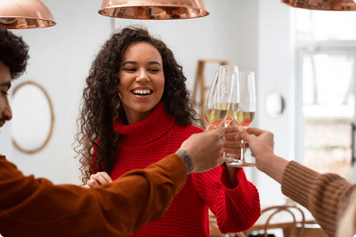 Group of friends raising wine glasses in a festive setting, enjoying Virgin Wines. Ideal for special occasions and celebrations. Wine discounts for disabled people.