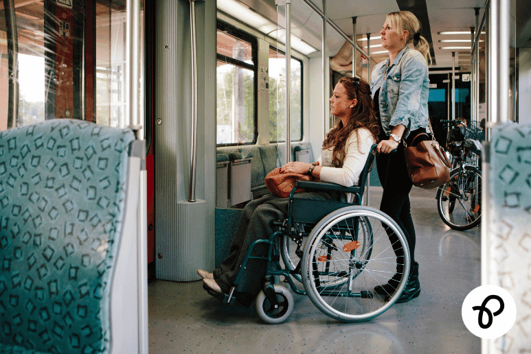 Disabled woman using a wheelchair travelling by train in the UK with companion support, representing Disabled Persons Railcard expansion 2026 and Disabled Travel Discounts UK for disabilities and long term health conditions, including Purpl discounts.